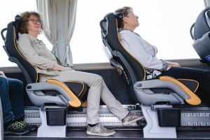 Zwei Damen sitzen gemütlich mit ausgestreckten Beinen im First-Class-Bus