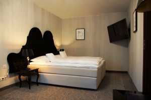 weißes Doppelbett in einem beigen Raum als Zimmerbeispiel (© www.natur-beratung-freizeit.de)