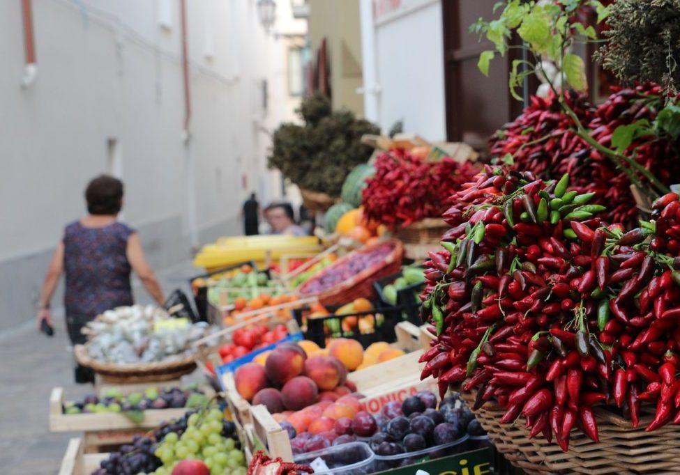 Apulien Flugreise Italien Marktstand mit vielen Chillischoten und Obst
