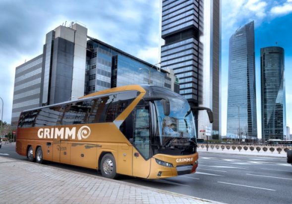 First Class Bus vor einer Skyline auf einer großen Straße