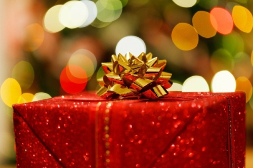 Weihnachtsgeschenk rot glitzernd und mit einer goldenen Schleife verpackt