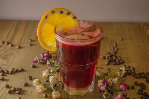 Gögli mit Mandarinenscheibe umringt von getrockneten Blumen und Kaffebohnen