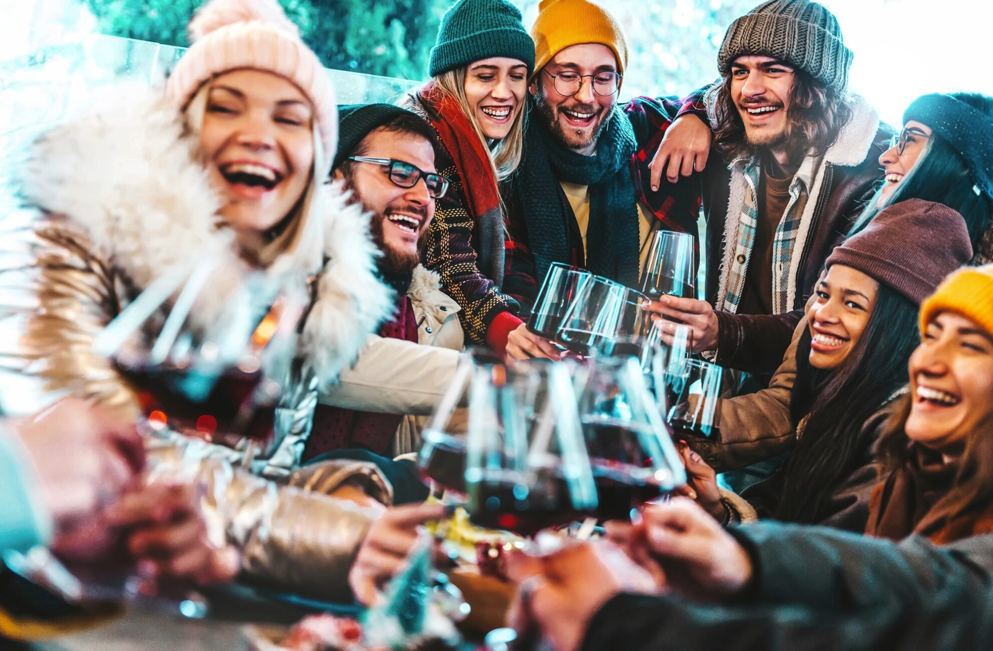 2694133-2620709-V1-P0-min Junge Gruppe stoßend lachend mit einem Glas Wein an.