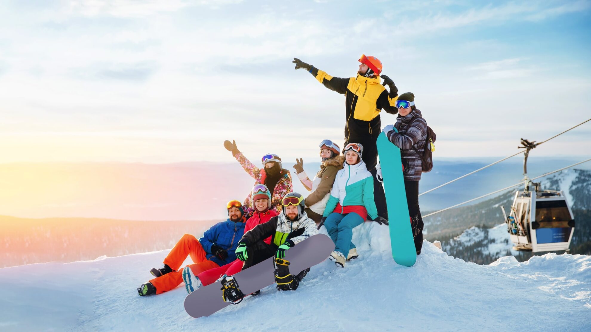 2707403-2633979-V1-P0-min Junge Gruppe im Skiurlaub mit Snowboards auf der Piste