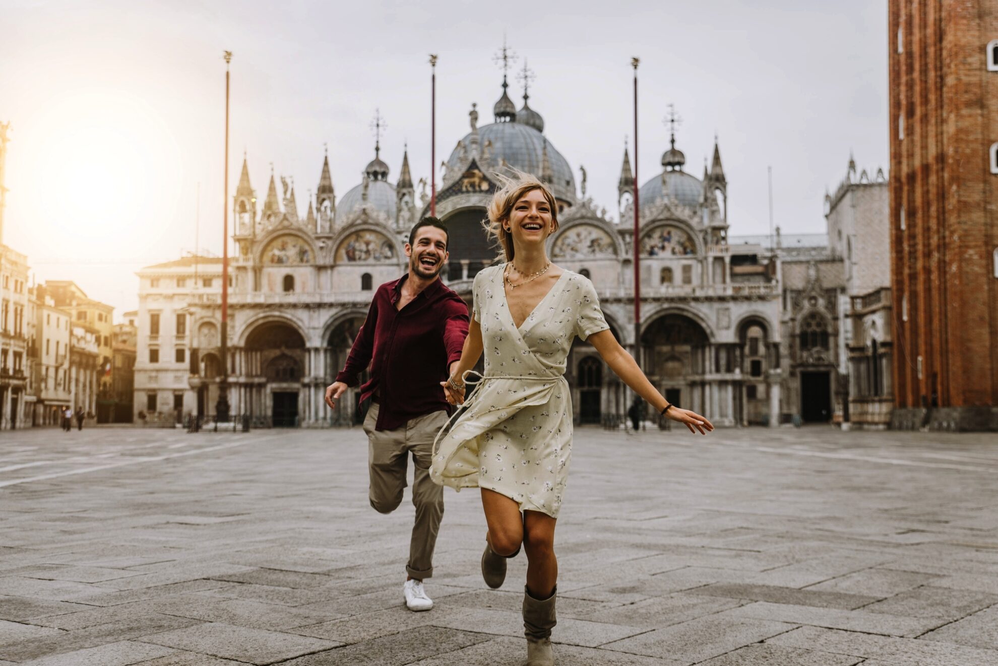 Couple of tourists visiting Venice, Italy - Boyfriend and girlfriend in love running together on city street at sunset - People, love and holidays concept ©Davide Angelini - stock.adobe.com