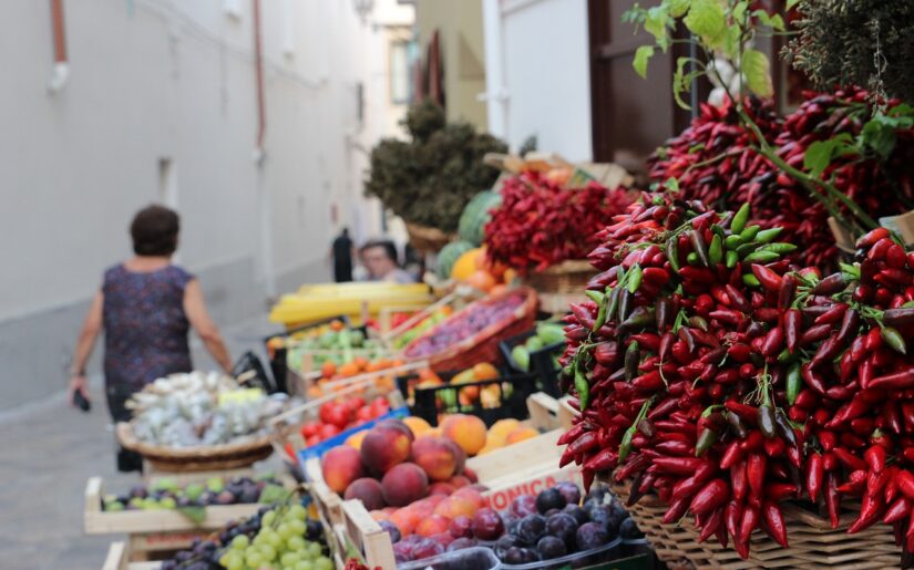 Apulien Flugreise Italien Marktstand mit vielen Chillischoten und Obst