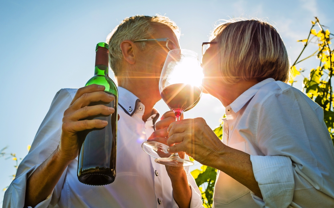 Senioren Paar stößt mit Wein an im Sommer Gegenlicht, Mann und Frau prosten sich zu - © Kzenon - Fotolia